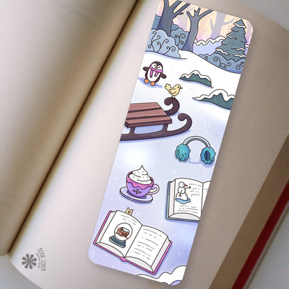 Winter Penguin Sled bookmark in an open book, cozy reading