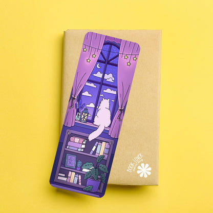 Bookmark with a purple design of a cat by a window on a yellow background