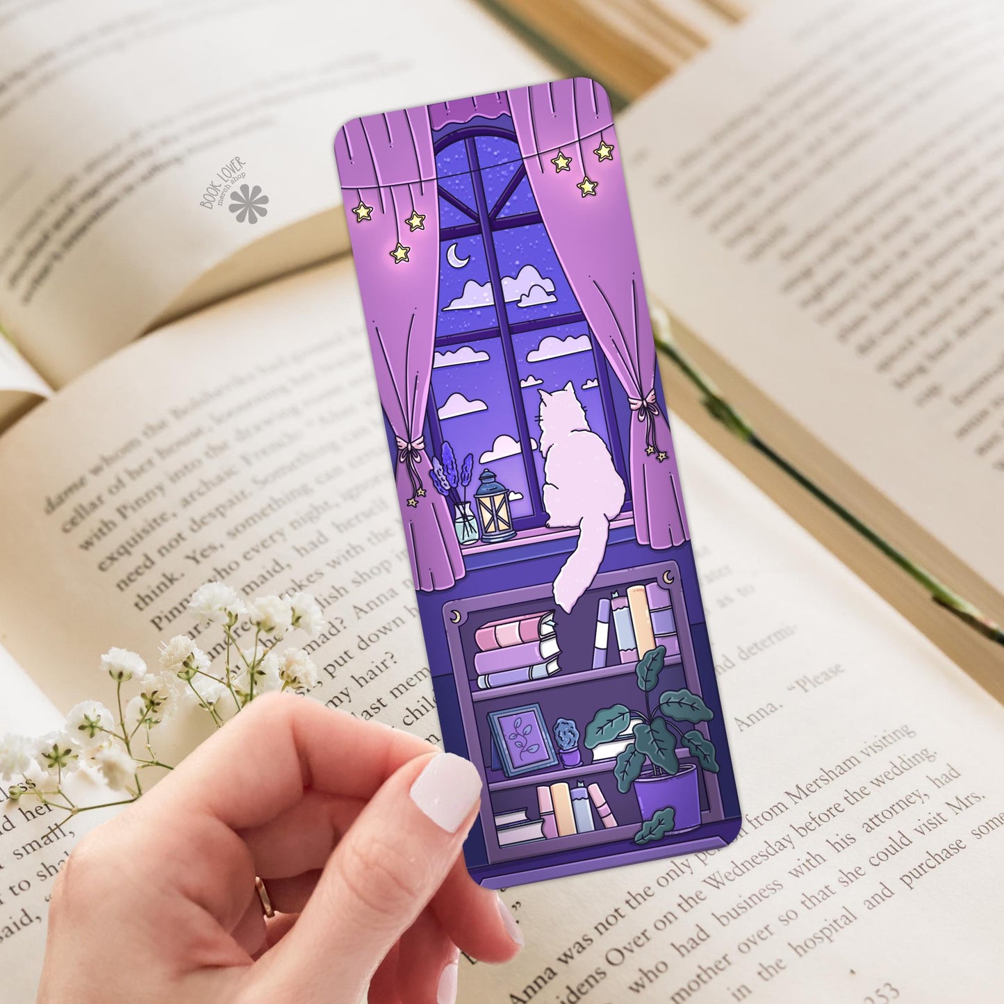 Cozy purple cat bookmark held over an open book